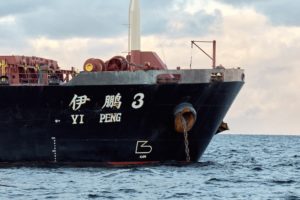 The front half of a black freight vessel at sea, with "Yi Peng 3" written in white along the side