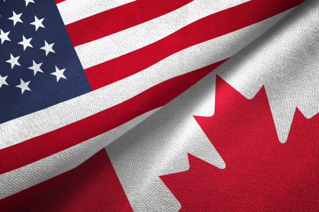 United States and Canadian flags juxtaposed across each other diagonally