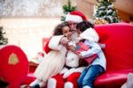 A SEATED MAN DRESSED AS SANTA IS HUGGED BY TWO CHILDREN IN A STORE iStock-manonallard-1091327698.jpg