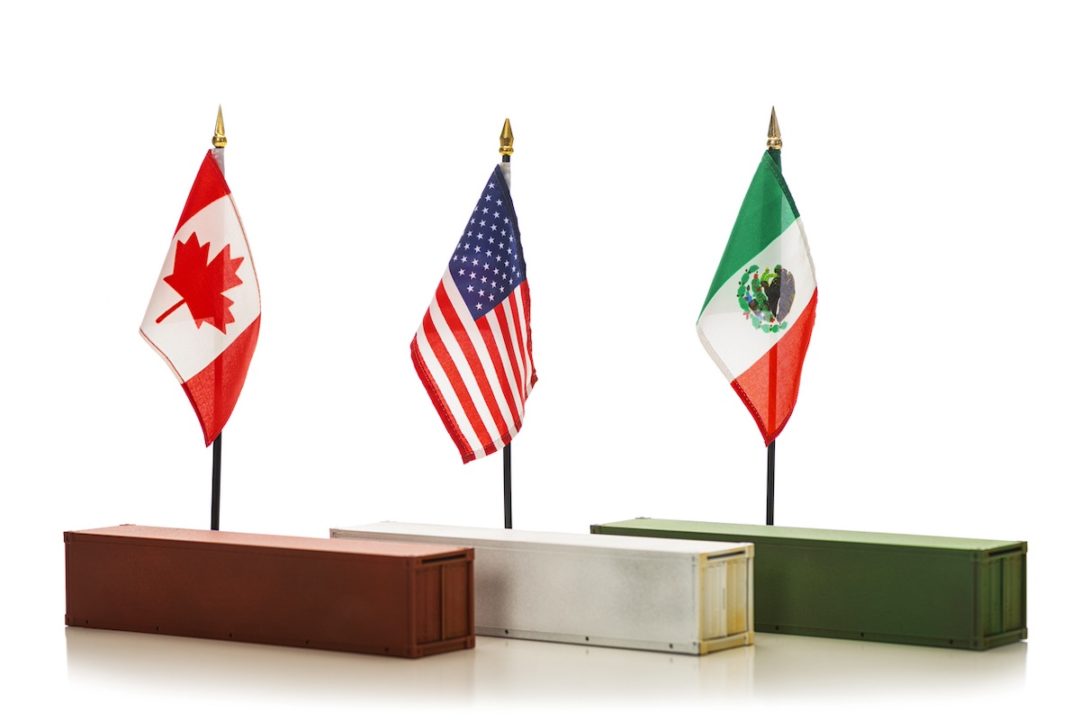 A Canadian, American, and Mexican Flag lined up in a row, on top of a red, white and green shipping container respectively