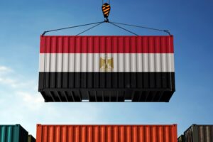 A shipping container with horizontal red, white and black stripes in the shape of Egypt's flag, with a gold eagle emblem at the center