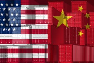 Stacks of shipping containers, with an American flag printed on the left side, and a Chinese flag printed across the right