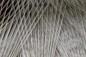 Close up texture of a lot of threads in a weaving machine called a loom