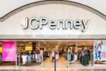 A tan storefront with white metal detectors spread across the open front entrance, and "JCPENNEY" written in large white lettering across the top