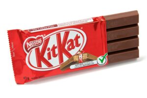 A KIT KAT CHOCOLATE BAR IS PARTIALLY UNWRAPPED.