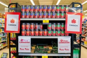 A SUPERMARKET DISPLAY OF TINNED TOMATOES AND SPAGETTI IS FESTOONED WITH SIGNS SAYING SHOP CANADIAN.