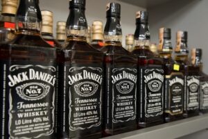 A ROW OF BOTTLES LABELED JACK DANIELS TENNESSEE WHISKEY SITS ON A SHELF